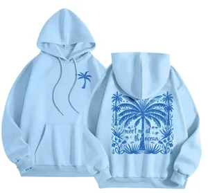 Close-up detail of light blue hooded sweatshirt with back palm tree print and text graphics.
