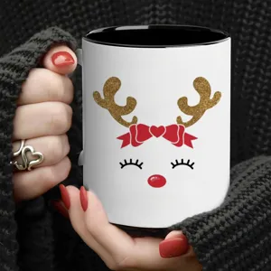 Weihnachten Keramik Kaffeetasse mit süßem goldenen Rentier und roter Schleife im Detail.