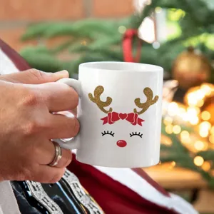 Weihnachtliche Keramiktasse mit süßem goldenem Glitzer-Rentier und roter Schleife für Kaffee.