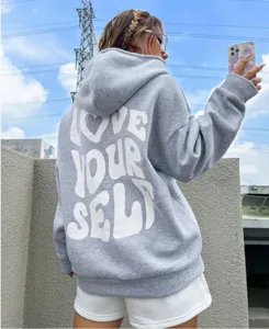 Détail dos sweat à capuche polaire gris, impression lettres blanches, style streetwear chic.