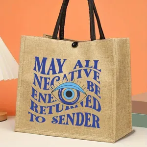 Jute tote bag featuring evil eye graphic and inspirational quote, durable daily shopping bag.