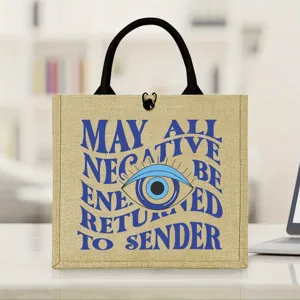 Detailed view of jute tote bag featuring evil eye print and spiritual typography design.