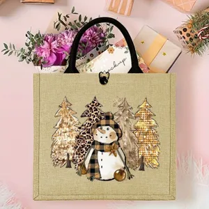 Bolsa de yute con muñeco de nieve navideño y asas negras, detalle de bolsa de regalo festiva.