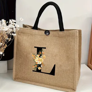 Detailed view of the burlap tote bag featuring a black letter L and floral print design.