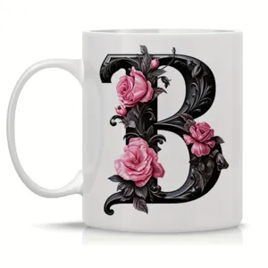 White ceramic coffee mug featuring an ornate black letter B and pink rose design.