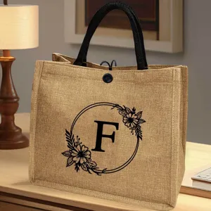 Bequeme Jute-Tragetasche mit floralem Buchstaben-Design, ideal für Strand, Alltag und Reisen.