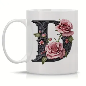 Detailed view of white ceramic coffee mug featuring ornate floral letter D design for office.