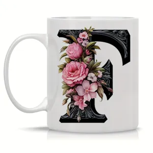 Detailed close-up view of the white ceramic coffee mug featuring ornate floral letter F design.