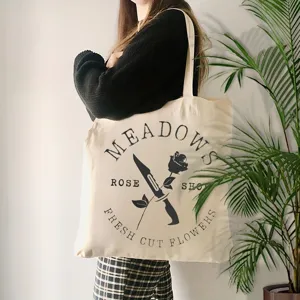 Λεπτομερής όψη της vintage τσάντας tote από καμβά με γραφική εκτύπωση και χωρητικότητα.