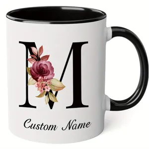 Custom letter M ceramic coffee mug with watercolor floral design and black handle for office.