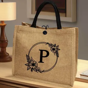 Jute Tragetasche mit schwarzen Henkeln und floralem Buchstaben P Druck für den Strand Einkauf.