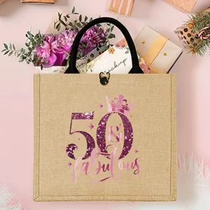 Close-up detail of the burlap tote bag with 50th birthday pink glitter crown print.