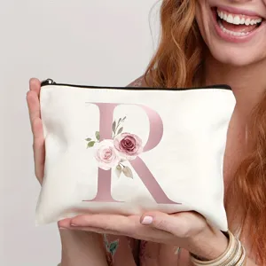 Detailansicht der weißen Canvas Kosmetiktasche mit rosafarbenem Buchstaben R und Blumen.