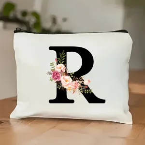 Nahaufnahme Detail der weißen Kosmetiktasche aus Leinen mit floralem Buchstaben.
