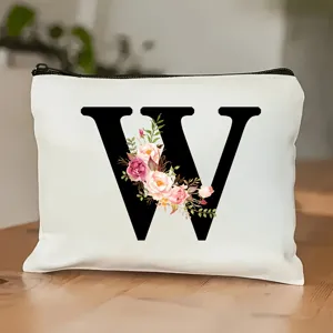 Detailansicht der weißen Kosmetiktasche mit schwarzem Buchstaben W und Aquarellblumen.