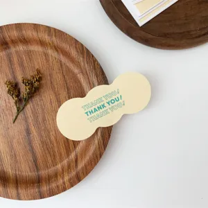 Detail shot of ins style yellow sealing sticker with thank you text on wooden tray.