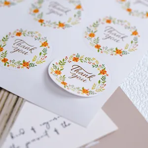Primer plano de pegatinas redondas de agradecimiento floral para embalaje y sellado.