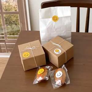 Detailed view of cute yellow smiley face stickers used for gift packaging, boxes, and bags.