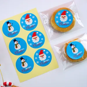 Detail view of blue Christmas Santa and snowman sticker sheet with decorated cookie packaging.