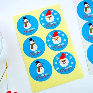 Details of round Christmas blue stickers featuring cute Santa and snowman for holiday packaging.