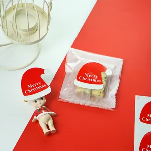 Détail d'autocollant de cachetage chapeau de Noël avec texte et emballage de bonbons.
