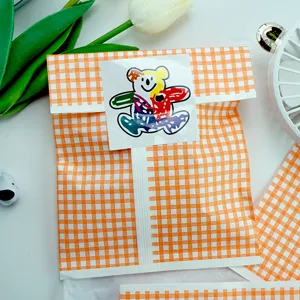 Detail shot of orange plaid greaseproof paper bag with cute cartoon bear sticker.
