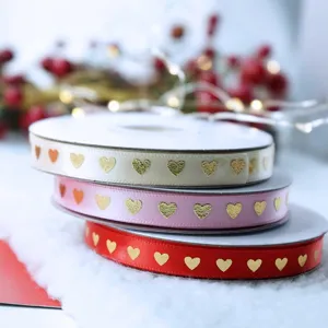 Gros plan de rubans en satin multicolores avec cœurs dorés, idéaux pour les emballages cadeaux.