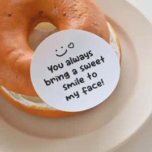 Autocollant décoratif rond avec joli visage souriant et citation douce pour emballage cadeau.