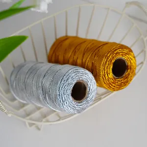 Metallic cord detail view, shiny gold and silver strings in wire basket for crafts.