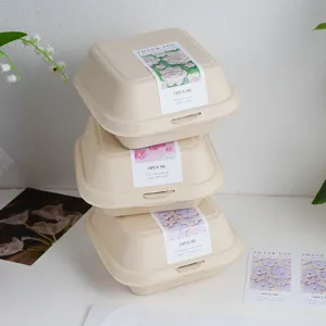 Scatole per hamburger biodegradabili in fibra vegetale con adesivi floreali, imballaggio ecologico.
