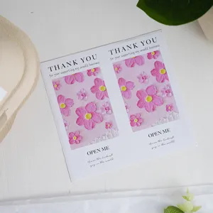 Primo piano di adesivi di ringraziamento rettangolari con motivo floreale rosa per regali.