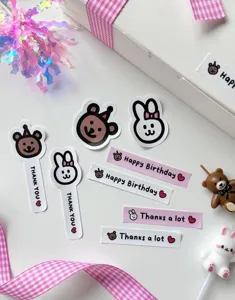 Close-up detail of cute pink and white adhesive stickers featuring cartoon bears, rabbits.