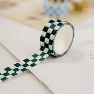 Gros plan de ruban washi à carreaux vert et blanc, parfait pour carnet et loisirs.