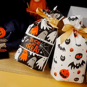 Halloween plastic candy gift bags detail view with gold ribbon bows for party packaging.