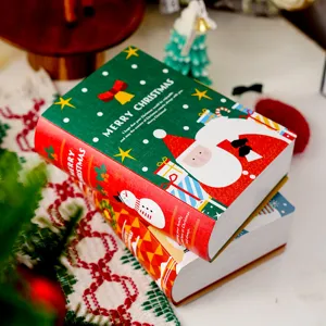 Dettaglio scatola regalo a forma di libro di Natale con stampa di Babbo Natale e pupazzo di neve.
