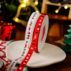 Christmas ribbon detail shot, red and white grosgrain ribbon rolls with holiday print.