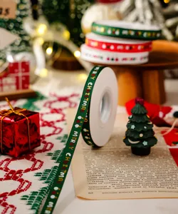 Christmas ribbon detail shot featuring green woven fabric with merry christmas print for gift wrapping.