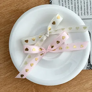 Joli ruban nœud avec cœurs dorés pour emballage cadeau, pâtisserie et décoration festive.