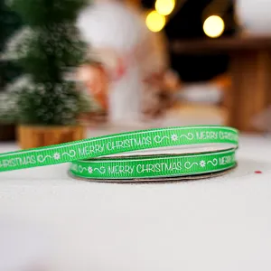 Κοντινό πλάνο πράσινης κορδέλας Merry Christmas με γιορτινό χριστουγεννιάτικο φόντο και ντεκόρ.