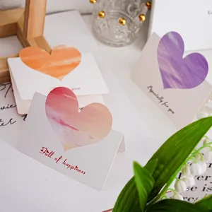 Gros plan sur les belles cartes de vœux pliantes en forme de cœur, design aquarelle.