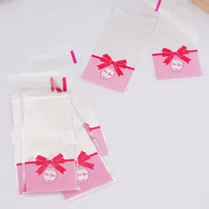 Transparente selbstklebende Kekstüten mit süßem rosa Schleifendesign für Süßigkeiten.