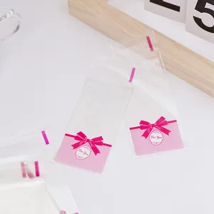 Transparente selbstklebende Verpackungen mit rosa Schleife fur Kekse und kleine Sundigkeiten
