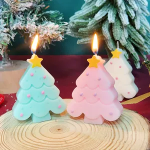 Vista dettagliata di candele profumate albero di natale multicolori con fiamma accesa su fetta di legno.