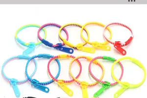 Détail de bracelets zippés en plastique coloré, jouets de décompression et accessoires amusants.