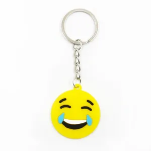Detailweergave van schattige lachende emoji PVC sleutelhanger met gele hanger en ring.
