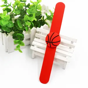 Primo piano del bracciale slap in silicone rosso con ciondolo da basket su una panchina.