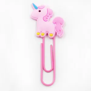 Detailopname van het schattige roze eenhoorn PVC cartoon personage op grote paperclip.