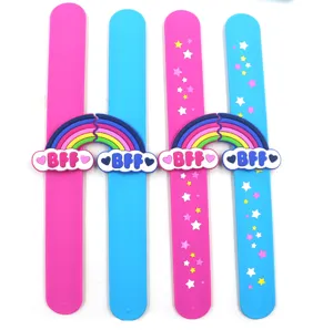 Vue détaillée de bracelets slap en silicone colorés avec des breloques arc-en-ciel et BFF.