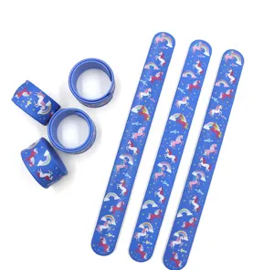 Vista dettagliata di bracciali slap in silicone blu con simpatici motivi di unicorno e arcobaleno.
