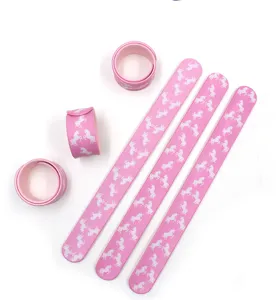 Bracciale a scatto in silicone rosa con simpatici motivi di unicorno bianco, primo piano.